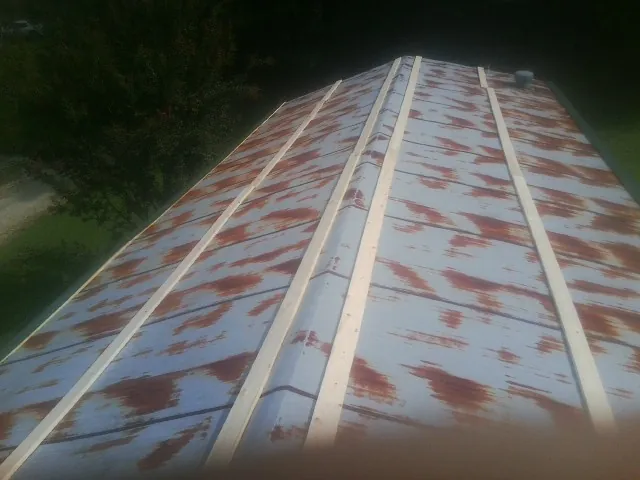 Rusted metal roof panels with new wood purlins before replacement — Storm Damage Roof Repair in Seaside by Roofing Brothers